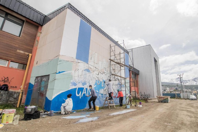 Trabajan en la pintura de un mural comunitario en homenaje a Diego Armando Maradona en Ushuaia